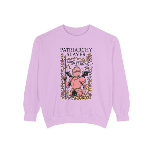 Comfort Colors garment-dyed sweatshirt featuring 'Patriarchy Slayer' design with pink armored knight holding sword and banner reading 'Burn It Down', surrounded by decorative floral border with roses and leaves. Made from 80% ring-spun cotton and 20% polyester with relaxed fit and rolled-forward shoulders. Available in lavender purple and seafoam green colorways, sizes S-3XL unisex, featuring sustainable made-to-order production with OEKO-TEX certified low-impact dyes and zero waste manufacturing process.